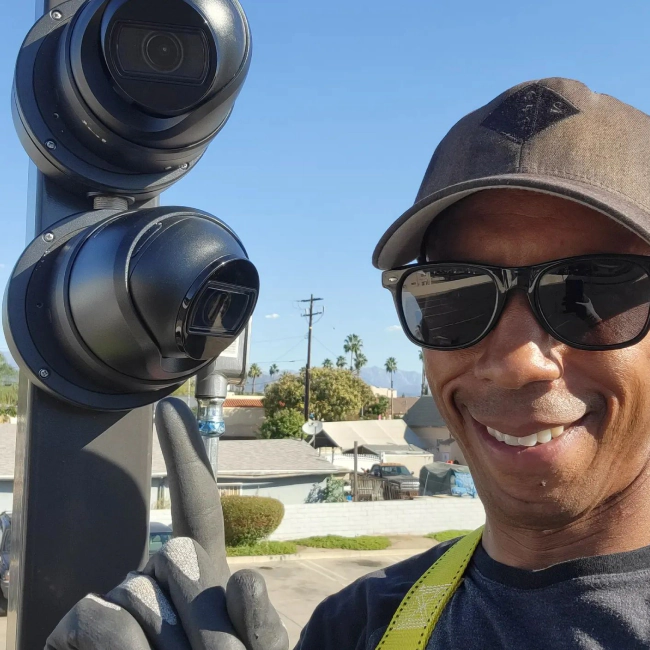 worker with black glasses installing some cctv systems